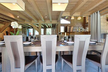 A dining room table with a bottle of wine on it
