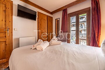 A hotel room with a large bed and a flat screen tv