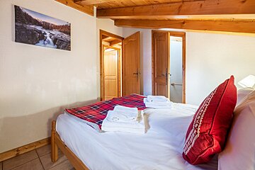 A bedroom with a picture on the wall above the bed