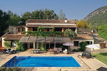 A large house with a large swimming pool in front of it