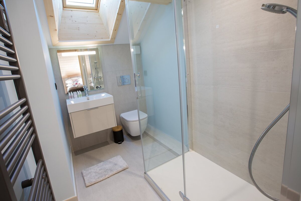 A bathroom with a toilet a sink and a shower