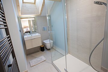 A bathroom with a toilet a sink and a shower