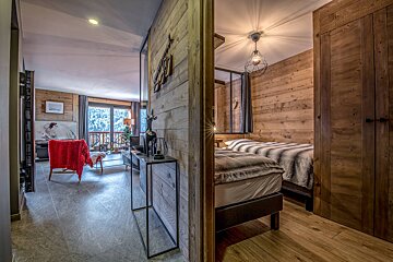 A bedroom with a wooden wall and a bed