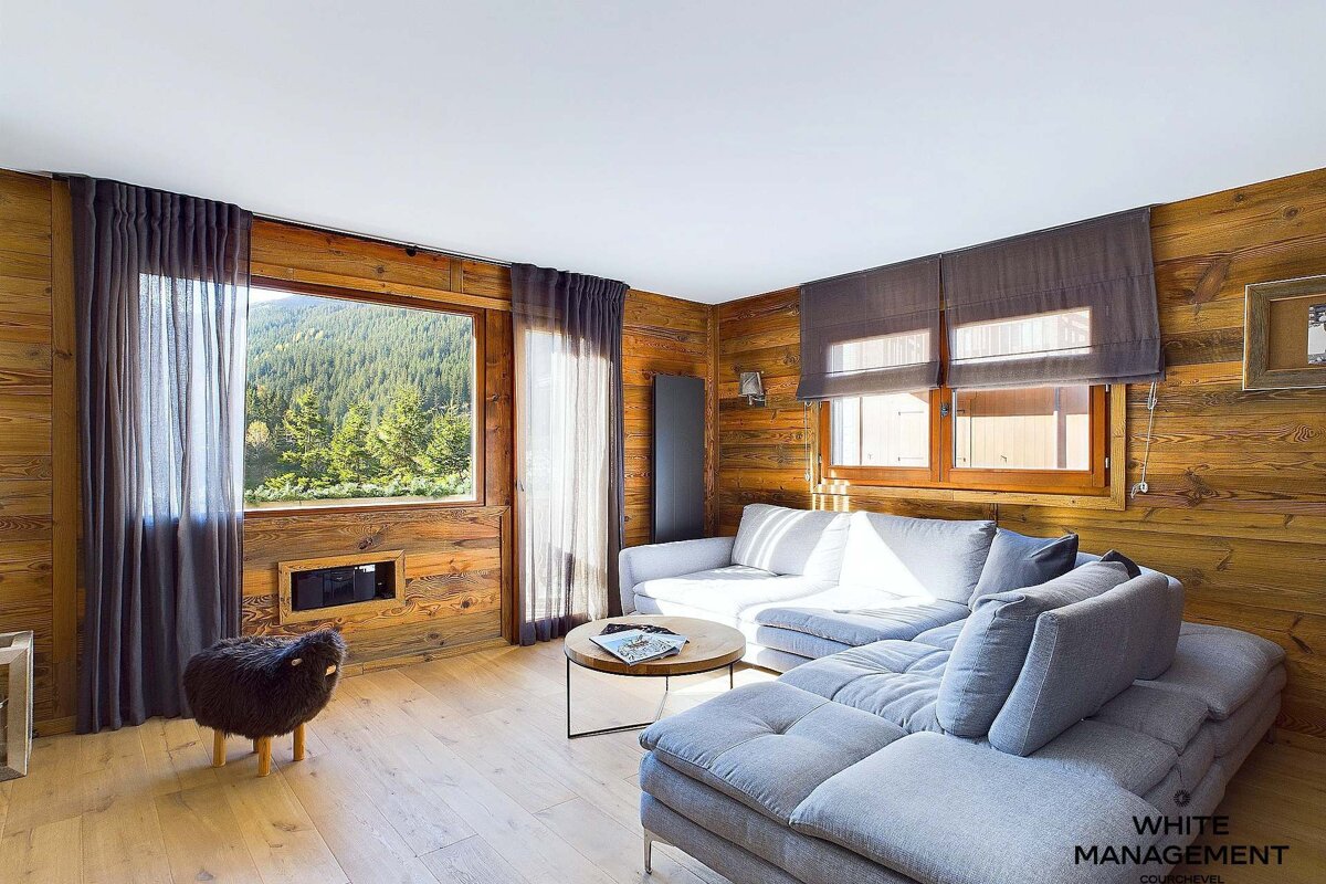 A living room with a couch and a table with white management written on the bottom