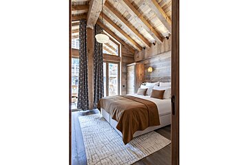 A bedroom with a wooden ceiling and a large bed
