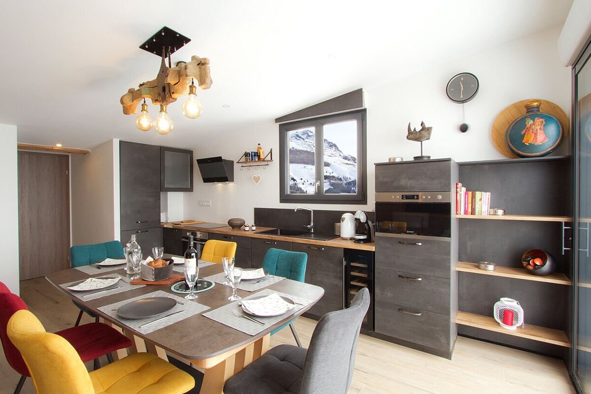 A kitchen with a table and chairs and a clock on the wall