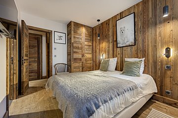 A bedroom with a bed and a picture of a polar bear on the wall