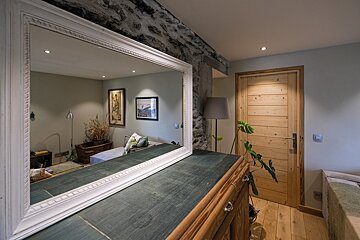 A large mirror sits on top of a wooden dresser
