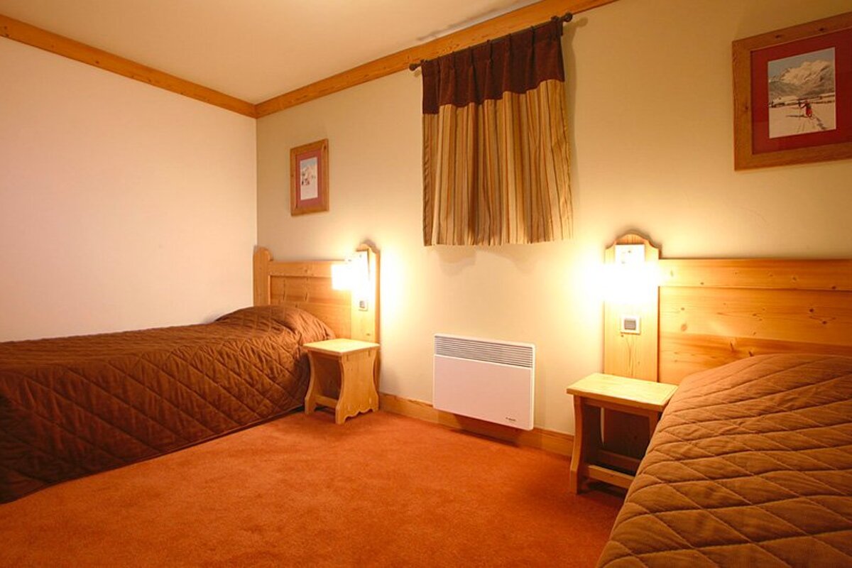 A bedroom with two beds and a picture on the wall