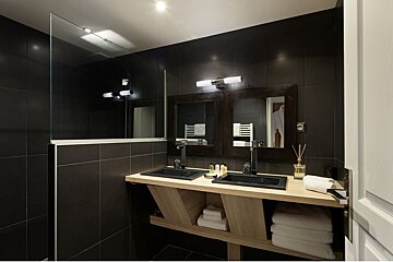 A bathroom with two sinks and two mirrors