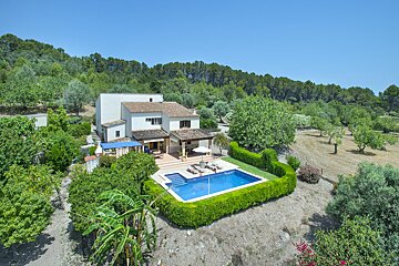 An aerial view of a house with a large swimming pool