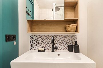 A bathroom sink with a soap dish and a soap dispenser