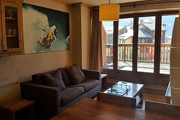 A living room with a couch and a painting on the wall