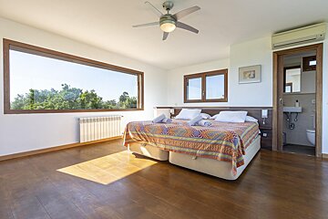 A bedroom with two beds and a ceiling fan