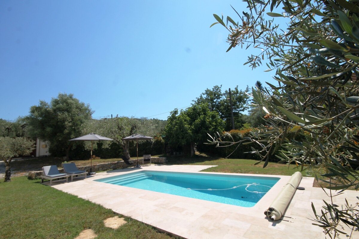A large swimming pool surrounded by chairs and umbrellas