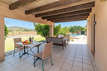A patio with a table and chairs and a bottle of wine