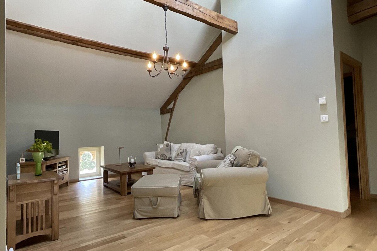 A living room with a couch and chairs and a chandelier