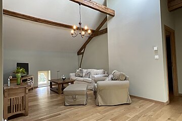 A living room with a couch and chairs and a chandelier