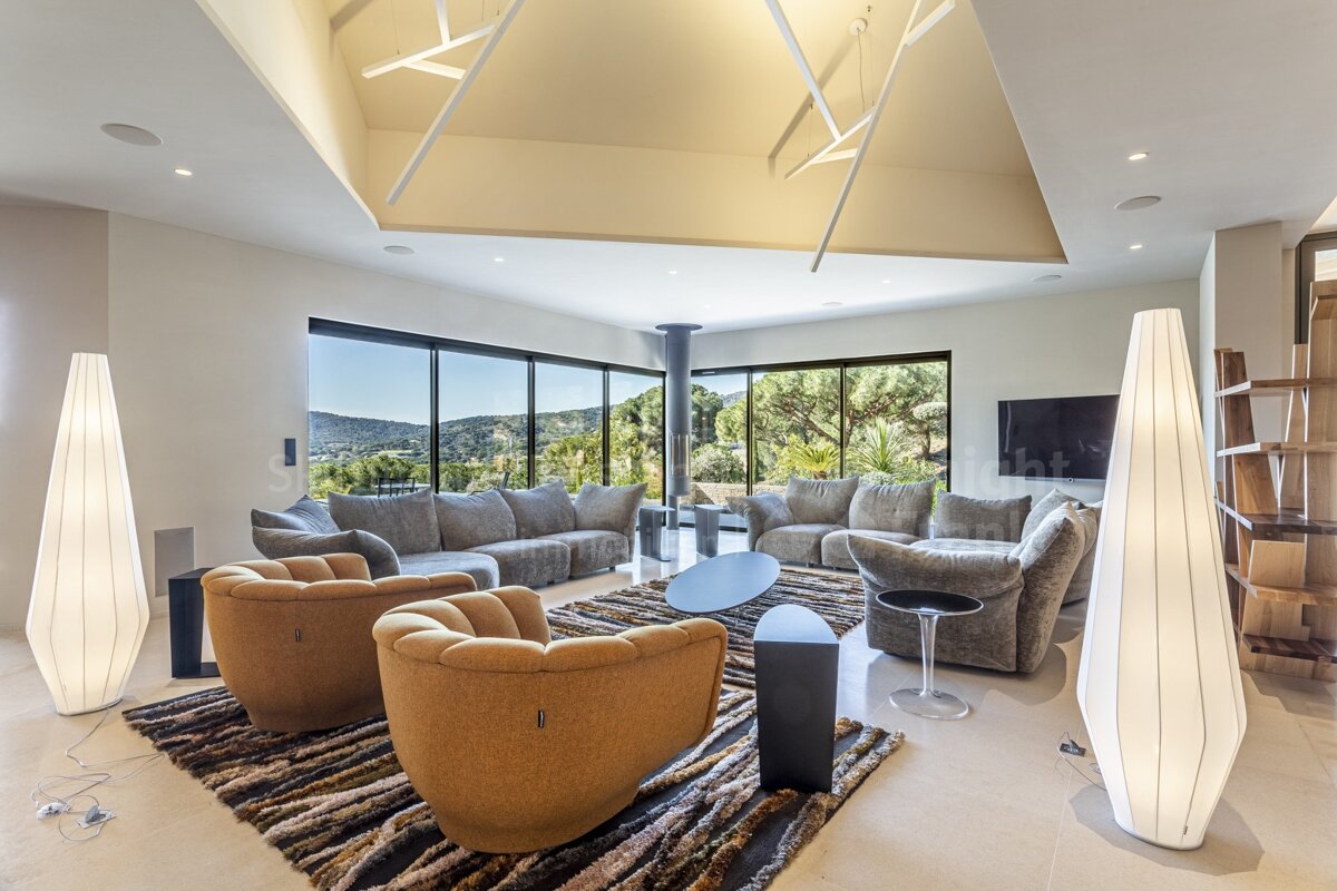 A living room with a couch and chairs and a rug