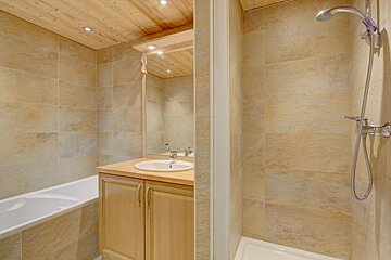 A bathroom with a sink and a shower