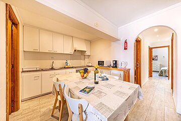 A kitchen with a table and chairs and a fire extinguisher on the wall