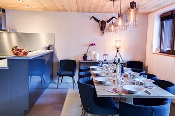 A dining room with a long table and blue chairs