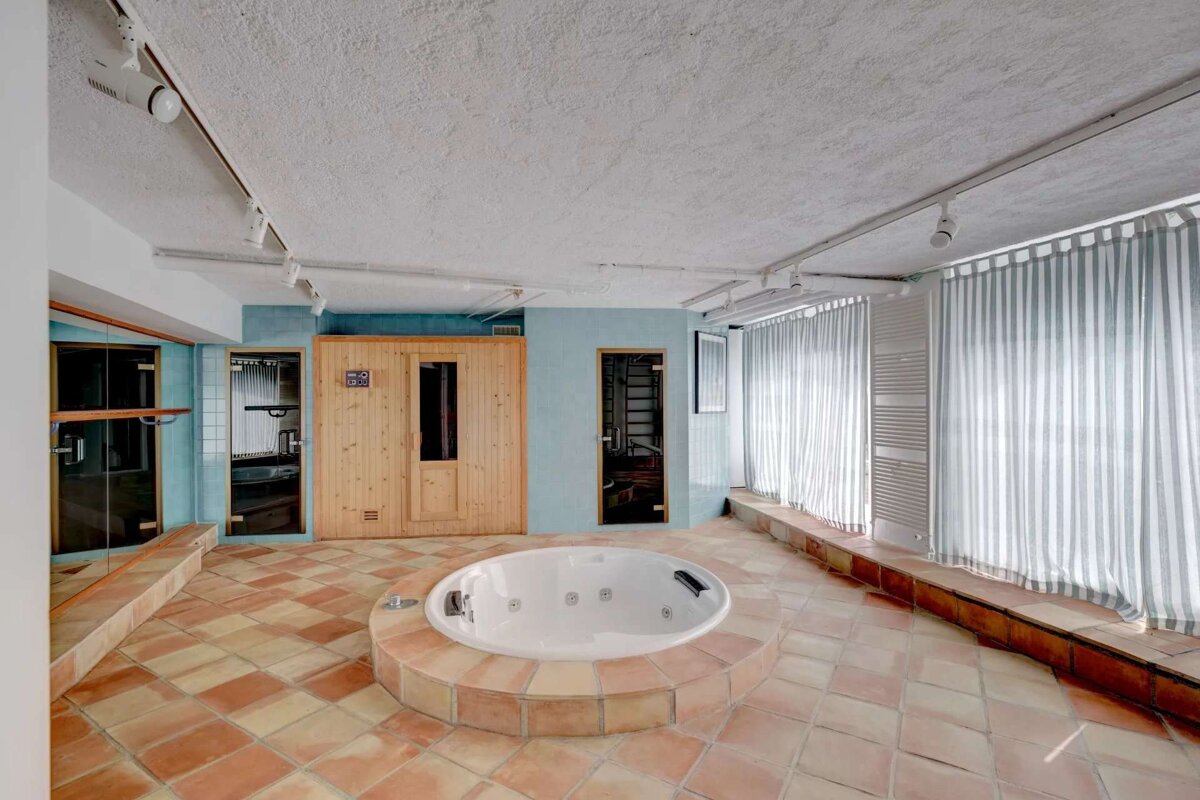A large room with a jacuzzi and a sauna