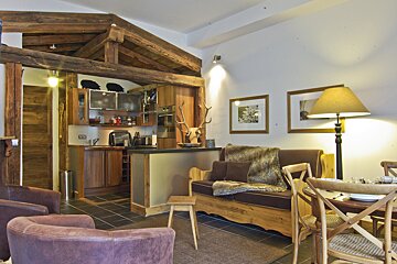 A living room with a couch and chairs and a lamp