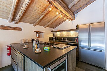 A kitchen with a stainless steel refrigerator and a stove top oven