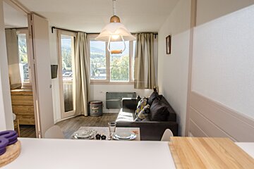 A living room with a couch a table and a window