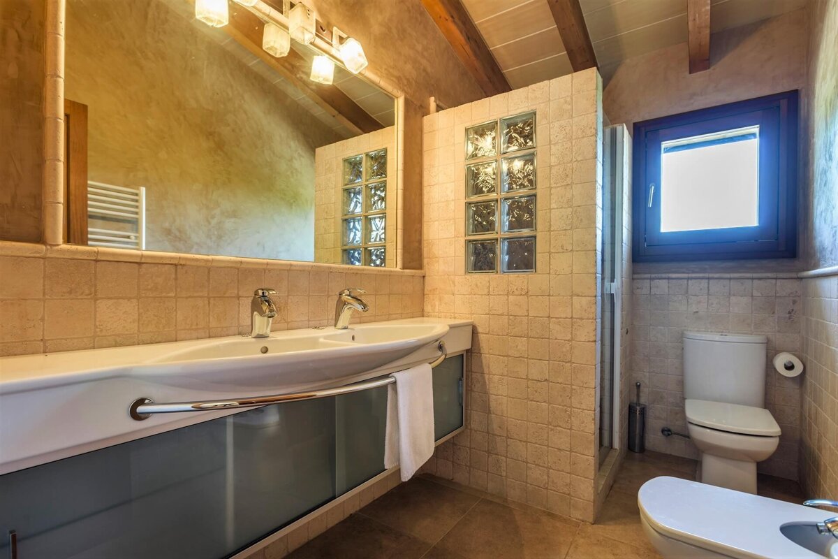 A bathroom with two sinks and a toilet