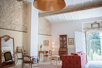 A living room with a couch a desk and a mirror