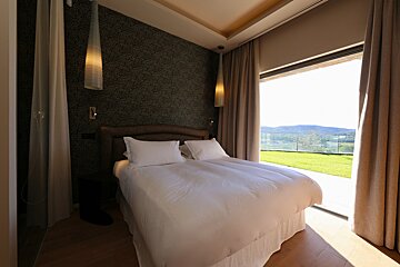 A bedroom with a large bed and a sliding glass door