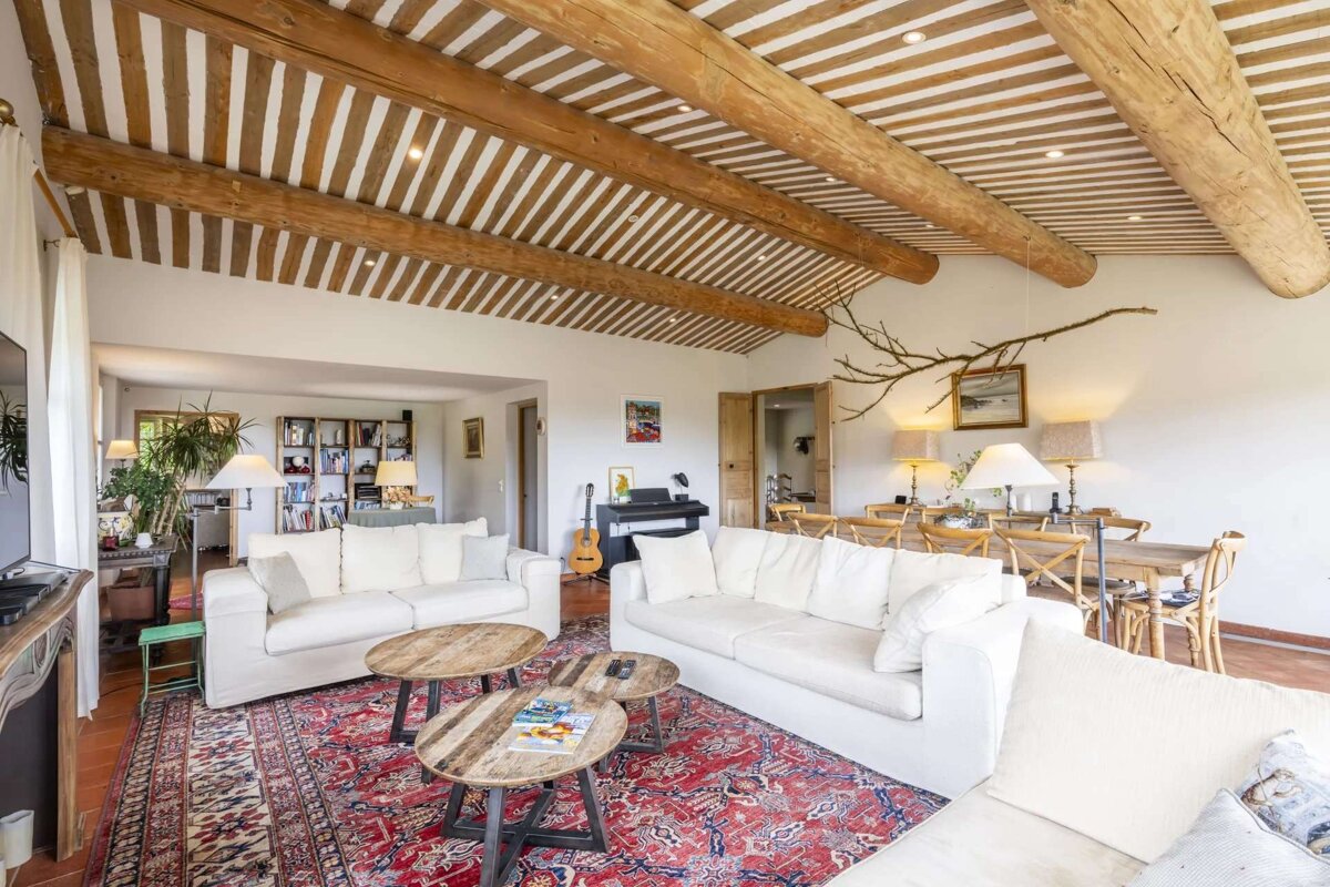 A living room with a striped ceiling and wooden beams