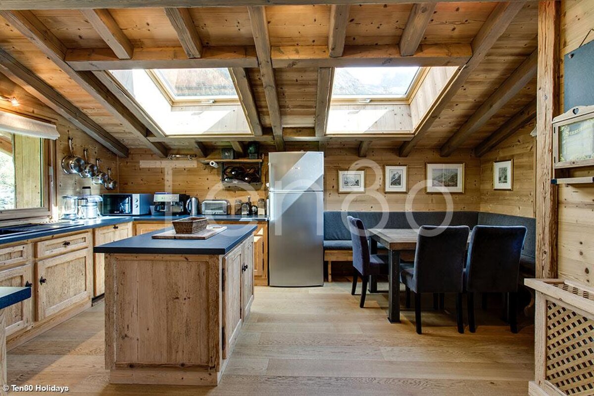 A kitchen with a stainless steel refrigerator and a table