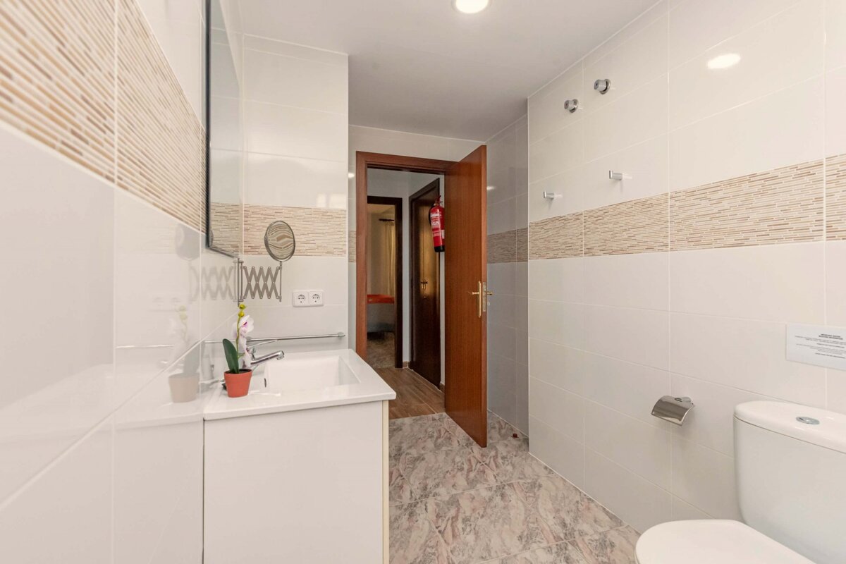 A bathroom with a toilet a sink and a mirror