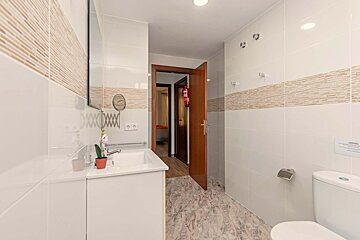 A bathroom with a toilet a sink and a mirror