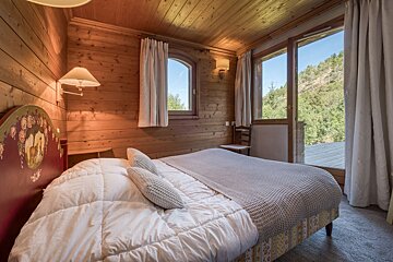 A bedroom with a large bed and a large window