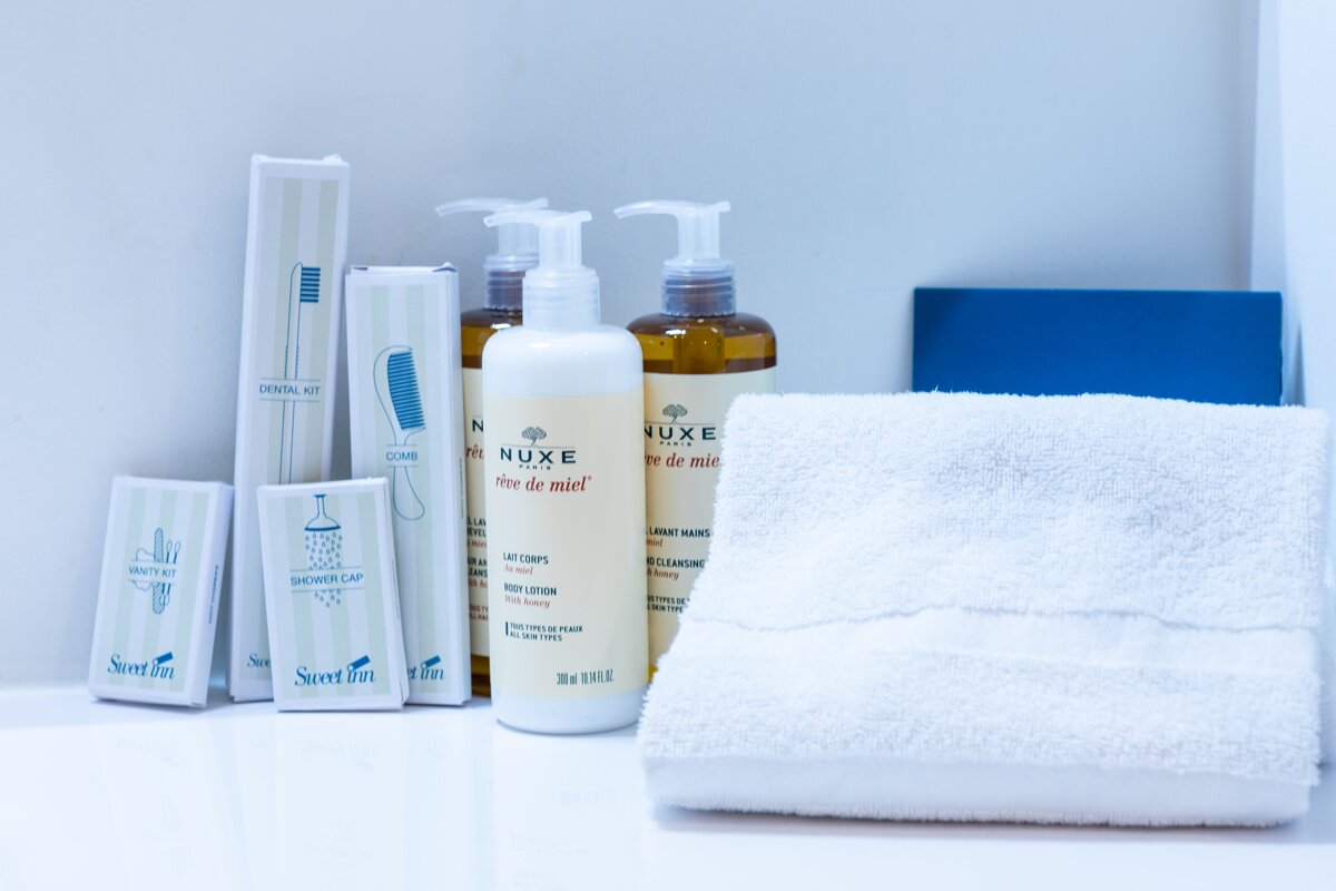 A bottle of nuxe creme de miel sits next to a towel