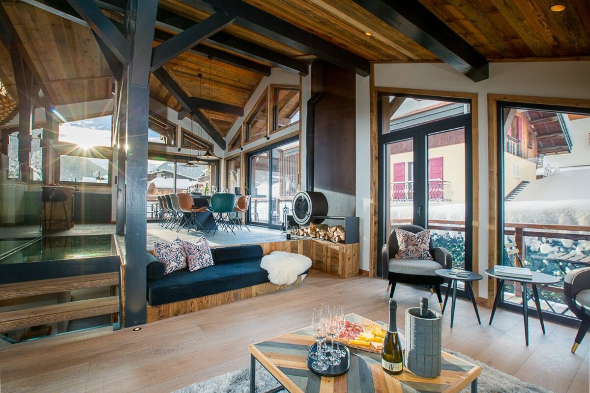 A living room with a couch and a table with a bottle of wine on it