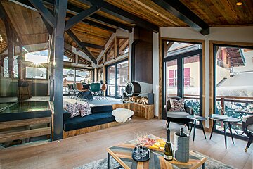 A living room with a couch and a table with a bottle of wine on it