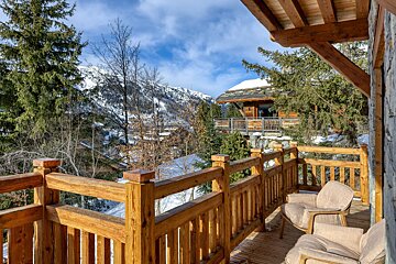 A wooden balcony with a view of snowy mountains