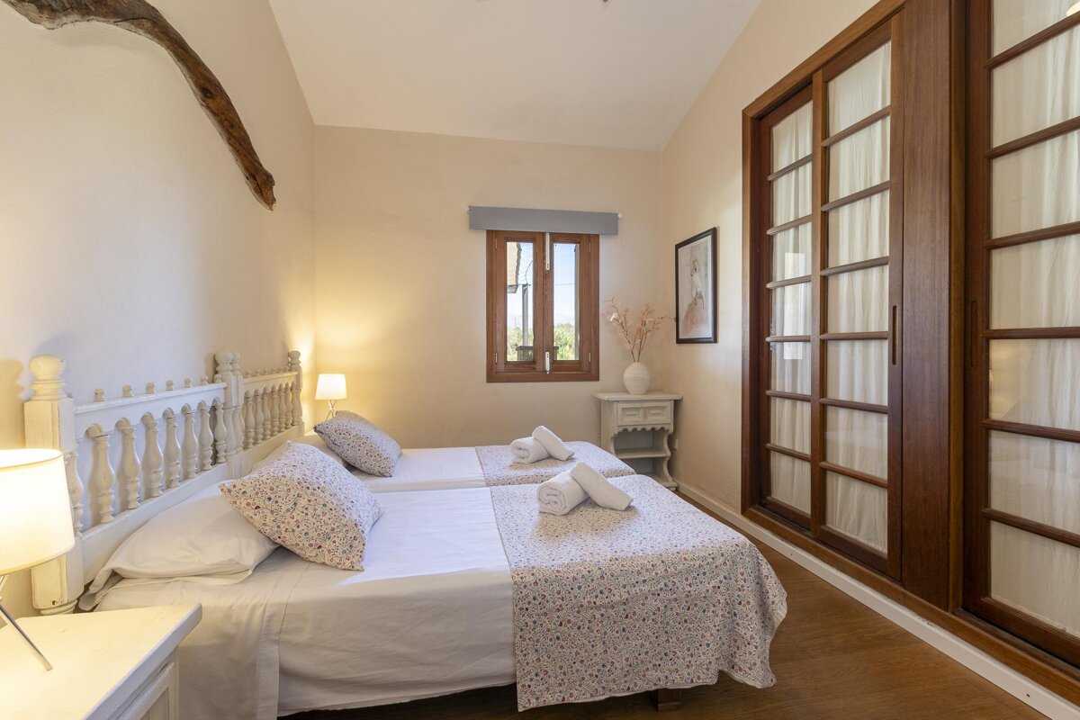 A bedroom with two beds and a sliding glass door