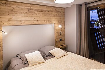 A bedroom with a bed and a wooden wall