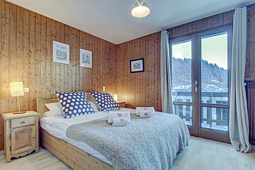 A bedroom with a king size bed and a window