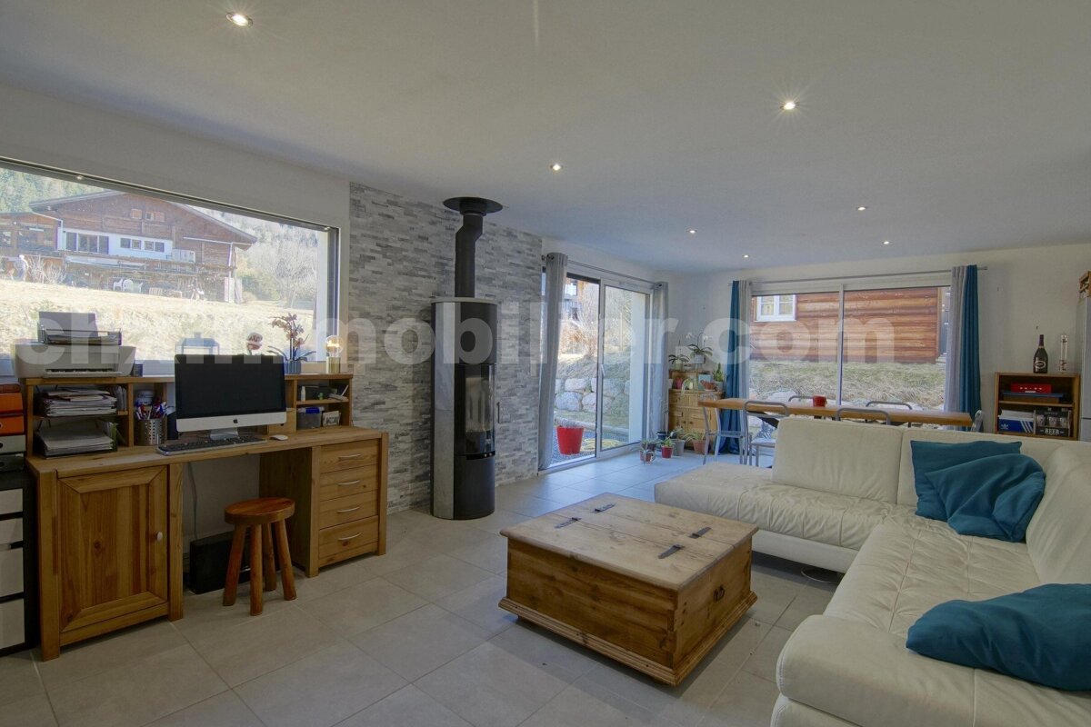 A living room with a couch and a desk with a computer on it