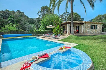 A swimming pool with a hot tub in front of it