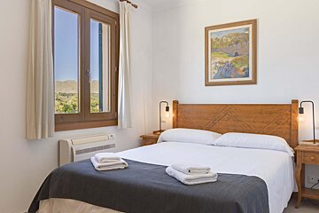 A bedroom with two beds and a painting on the wall