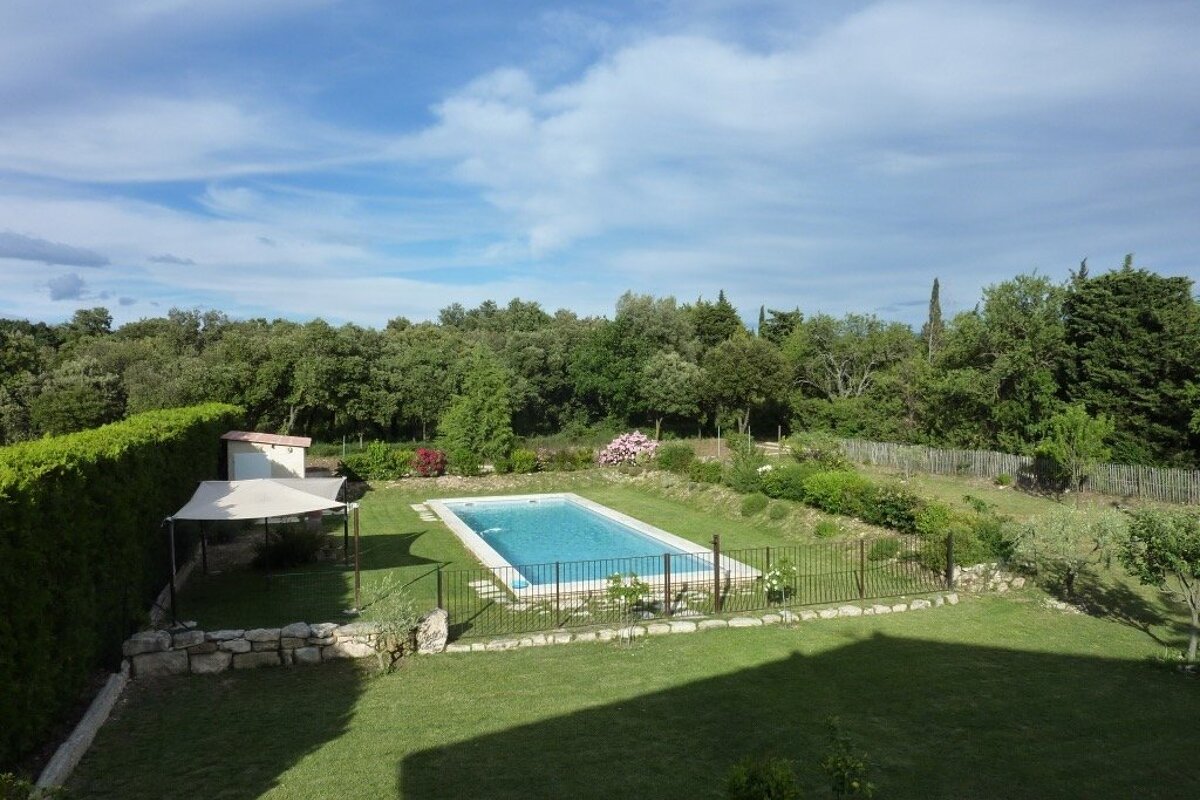 A large swimming pool in the middle of a lush green yard