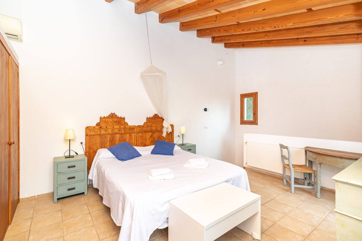 A bedroom with a wooden headboard and blue pillows